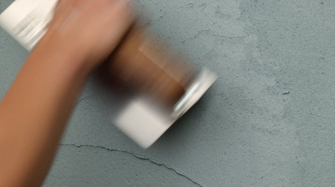 eine Hand mit Spachtel, die Mineralputz verarbeitet