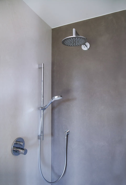 fugenlose Dusche in Beton Ciré mit silberner Armatur