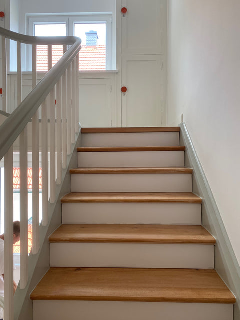 Altbautreppenhaus mit Holztreppe und weiss lackiertem Geländer, Handlauf grün lackiert