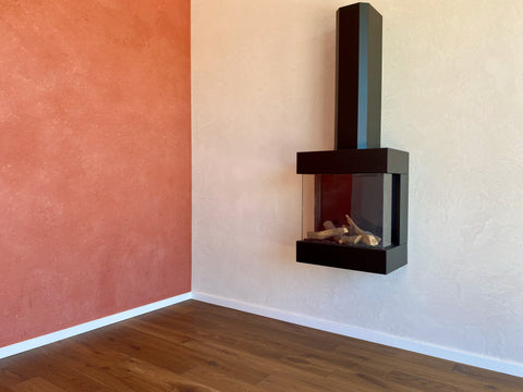 MIneralputz in Rot und in in Beige mit schwarzem Kamin davor