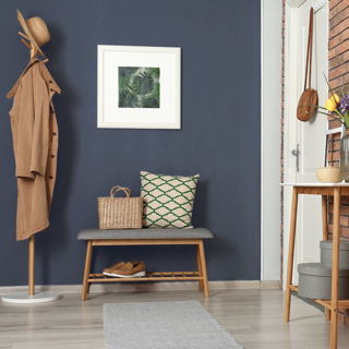 Hausflur mit wohngesunder Wandfarbe in elegantem Dunkelblau – kombiniert mit Garderobe, Holzbank und natürlichen Materialien für ein stilvolles und schadstofffreies Wohnambiente.