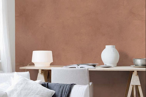 braune Putzwand hinter hellen möbeln