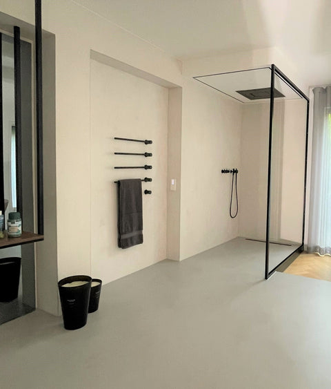 Fugenlose, wasserfeste Dusche mit Mineralputz in hellem Beige – modernes Badezimmer mit begehbarer Dusche, edlem Putz in  minimalistischem Design