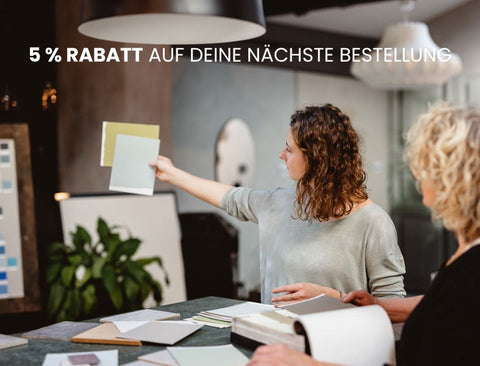 Zwei Malermeisterinnen prüfen in ihrem schönen Büro Farbmuster bevor diese an einen Kunden geschickt werden.