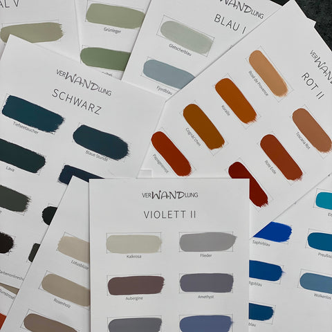 Verschiedene Farbübersichten der VerWANDlung Farbkollektion mit handgestrichenen Farbmustern in Blau, Rot, Violett, Grün und dunklen Farbtönen.
