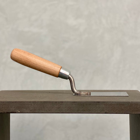 Stuckateurkelle mit Holzgriff in flacher Seitenansicht zum Auftragen und Verarbeiten von Mineralputz.
