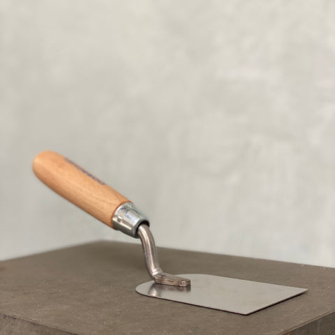 Stuckateurkelle mit Holzgriff und Edelstahlblatt zum Auftragen und Verarbeiten von Mineralputz.