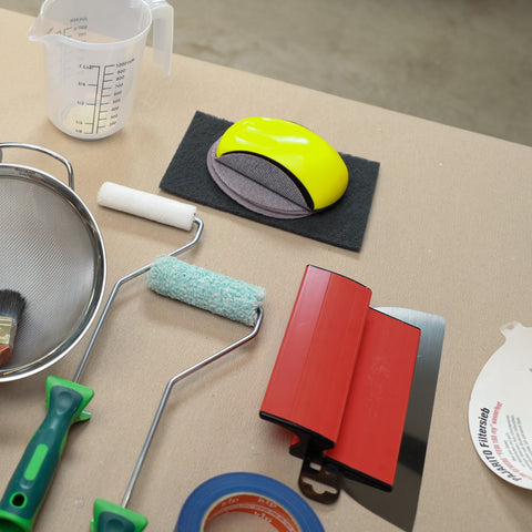 Werkzeugset für Beton Ciré mit Farbwalzen, PutzPerfekt, Schleifpad, Schleifmittel, Klebeband und weiterem Zubehör zur Verarbeitung.